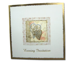 bright gold and white wedding invitation with imprinted hearts in the centre with a floral border